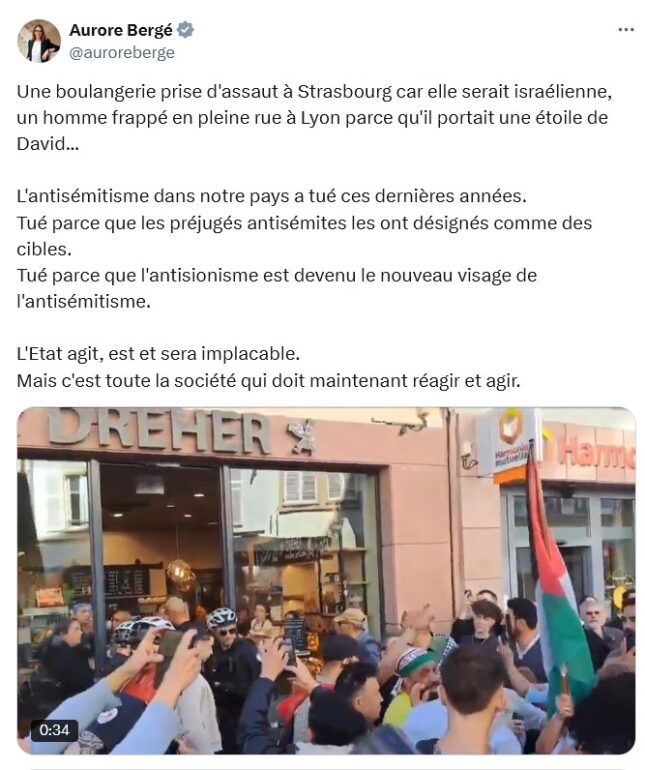 Policiers entre une boulangerie et des manifestants avec des drapeaux palestiniens