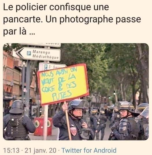 Un policier tient une pancarte qu'il vient de confisquer.