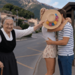 Image représentant la chanson Gordolasque. On y voit une vieille Niçoise en costume traditionnel cacher malicieusement un baiser entre deux amoureux.